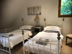 1 dormitorio con 2 camas y mesa con lámpara en Les Jonquilles en Domme