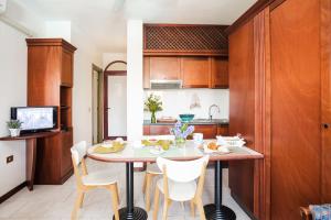 cocina y comedor con mesa y sillas en Residenza dei Cavalleggeri, en San Vincenzo