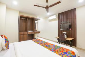 Schlafzimmer mit einem Bett, einem Schreibtisch und einem TV in der Unterkunft FabHotel Nirvana Residency in Neu-Delhi