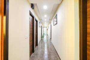 einen Flur eines Hauses mit weißen Wänden und Betonböden in der Unterkunft FabHotel Nirvana Residency in Neu-Delhi