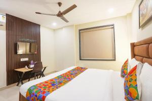 Schlafzimmer mit einem Bett, einem Tisch und einem TV in der Unterkunft FabHotel Nirvana Residency in Neu-Delhi