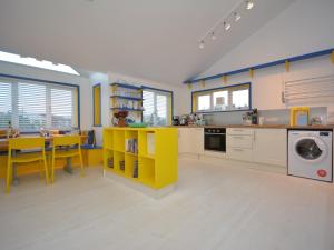 a kitchen with a yellow table and a yellow counter at 2 bed in Llansteffan 74268 in Ferryside