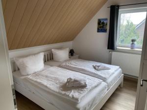 a bedroom with a bed with white sheets and a window at Reethaus Vilmnitz Reethaus Vilmnitz - Fewo "Muglitz" in Vilmnitz