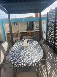 d'une table et de chaises sur un balcon avec une table et un toit. dans l'établissement Magnifique villa , piscine ,hamam près des plages, à Pérols