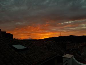 una puesta de sol sobre los tejados de una ciudad en Sunset APPART, en Brignoles