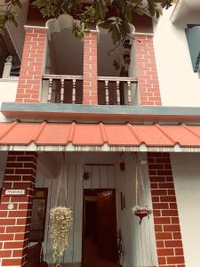 a house with a red awning and a door at Vibes of Varkala Homestay in Varkala