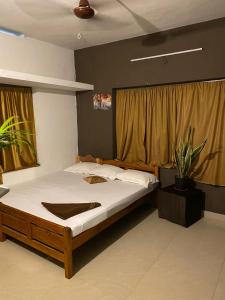 a bedroom with a large bed with white sheets at Vibes of Varkala Homestay in Varkala