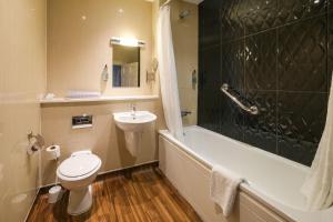 a bathroom with a sink and a toilet and a bath tub at The Unicorn Hotel Wetherspoon in Ripon