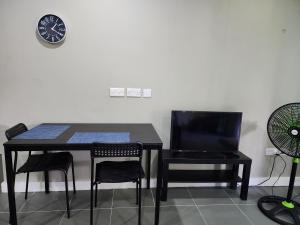a black table and chairs and a clock on a wall at Cozy 1-bedroom apartment in Frequente, St. George 