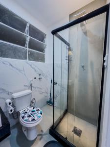 a bathroom with a toilet and a glass shower at Loft Moderno e Charmoso em Teresópolis - Alto in Teresópolis