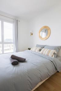 una camera bianca con un grande letto con specchio di Magnifique 2 pièces avec terrasse, Paris La Défense a Courbevoie