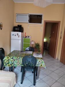 a kitchen with a table and chairs and a refrigerator at Lina House in Giardini Naxos