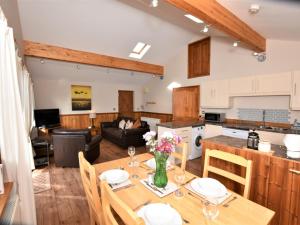 a kitchen and a living room with a table with flowers on it at 2 Bed in Ledbury 77377 