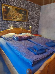 a large bed with blue comforter and two robes on it at Ferienwohnung in Malente