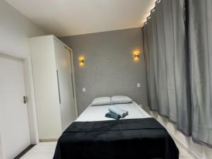 a bedroom with a bed with a black blanket at Loft Moderno e Charmoso em Teresópolis - Alto in Teresópolis