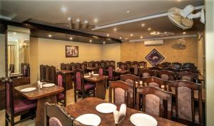 a restaurant with tables and chairs in a room at Florence Continental Udaipur in Udaipur