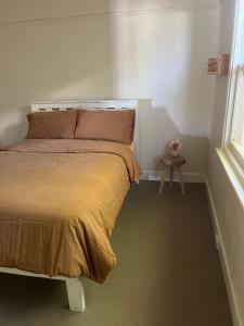 ein Schlafzimmer mit einem Bett und einem Tisch neben einem Fenster in der Unterkunft Bendigo Goldmines Abode in Golden Square