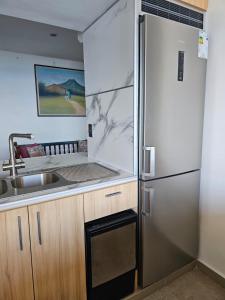 una cucina con frigorifero in acciaio inossidabile e lavandino di Apartamento El Vigía a Pampatar