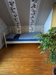 a bedroom with a bed with blue sheets and a wooden floor at Ferienhaus Brigitte in Dichtelbach