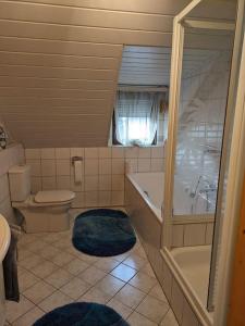 a bathroom with a tub and a toilet and a sink at Ferienhaus Brigitte in Dichtelbach +8 photos