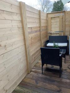 a patio with two chairs and a bench and a fence at Annex D. One Bedroom flat in south London in Carshalton