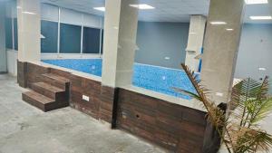 a large swimming pool in a building with blue walls at Farm with 5 huts, heated pool and bonfire in Gurgaon