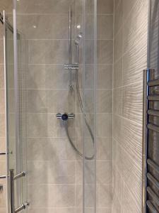 a bathroom with a shower with a glass door at Annex D. One Bedroom flat in south London in Carshalton