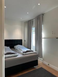 1 dormitorio con 1 cama en una habitación con ventana en Luxury Apartment In City Hotspot, en Gotemburgo