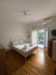 a bedroom with a bed and a sliding glass door at Modern, ideally located studio apartment in Athens