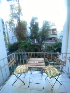 a wooden table and two chairs on a balcony at Modern, ideally located studio apartment in Athens