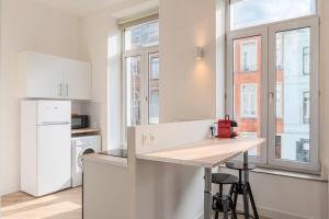 a kitchen with white cabinets and a counter top at Spacious and bright studio in the center. in Lille