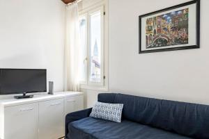 威尼斯的住宿－iHOMES Rialto-Corte del Calice-Attico vista centro，客厅配有蓝色的沙发和电视