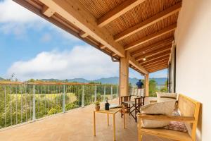 a patio with a table and chairs and a balcony at Domu Bresca in Muravera