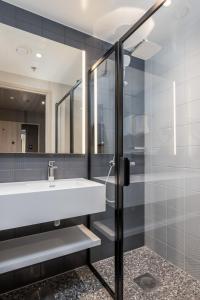 ein Bad mit einem Waschbecken und einer Dusche in der Unterkunft Citybox Helsinki in Helsinki