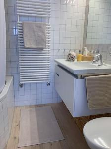 Sonniges und stylishes Bijou in St. Moritz Bad في سان موريتز: حمام أبيض مع حوض ومرحاض