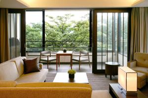 a living room with a couch and a large window at Hyatt Regency Hakone Resort and Spa in Hakone