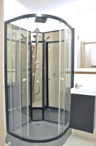 a glass shower in a bathroom with a sink at Nice and comfy studio close to Old town and metro. in Warsaw
