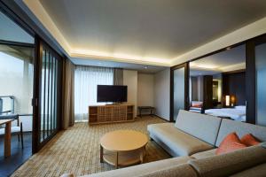 a living room with a couch and a tv at Hyatt Regency Hakone Resort and Spa in Hakone
