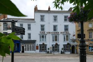 The Unicorn Hotel Wetherspoon في ريبون: مبنى ابيض مع لافته لفندق يونيكورن