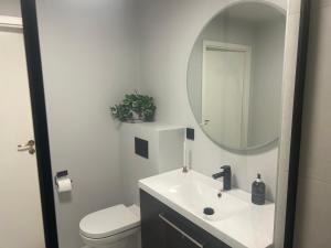 a white bathroom with a sink and a mirror at Huseby - Perfect for World Cup Trondheim 2025 in Trondheim