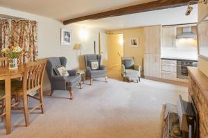 ein Wohnzimmer mit zwei Stühlen und einem Tisch in der Unterkunft Valley View Farm Holiday Cottages in Helmsley