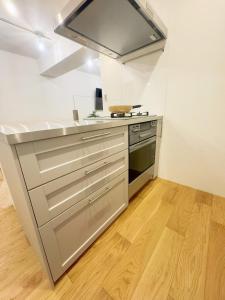 a kitchen with stainless steel appliances and wood floors at 山手線恵比寿8分　4人可　 in Tokyo