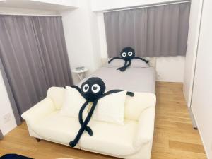 a bedroom with a couch and a bed withooky eyes at 山手線恵比寿8分　4人可　 in Tokyo