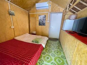 um pequeno quarto com uma cama e uma televisão em Wangsarai Resort em Don Sak