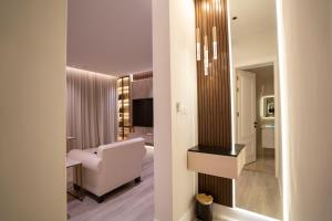 un soggiorno con sedia bianca e specchio di Riyadh Comfort Stay - Luxury الملقا Almalqa, 3 Bedrooms a Riyad