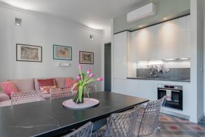 a dining room with a table with a vase of flowers at Luxury For Groups & Families in city center in Turin