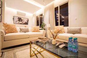 uma sala de estar com um sofá branco e uma mesa de vidro em Riyadh Comfort Stay - Luxury الملقا Almalqa, 3 Bedrooms em Riade