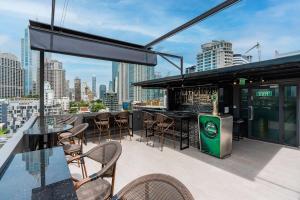 a rooftop bar with chairs and a view of a city at SureStay Plus by Best Western Sukhumvit 2 in Bangkok