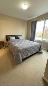 ein Schlafzimmer mit einem Bett und einem großen Fenster in der Unterkunft Cozy house in Langley in Langley