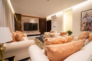 Riyadh Comfort Stay - Luxury الملقا Almalqa, 3 Bedrooms في الرياض: غرفة معيشة مع كنب وتلفزيون بشاشة مسطحة
